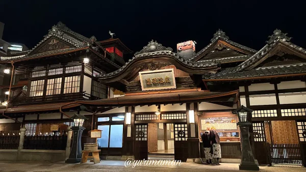 道後温泉本館の夜景。歴史的な建物がライトアップされている。