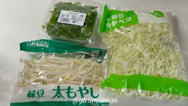 購入した野菜類。もやし、刻みねぎ、千切りキャベツのパックが並んでいる。