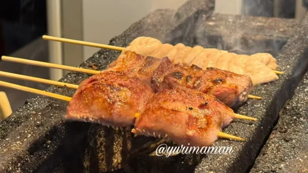 松山市二番町にある隠れ家風居酒屋「つばき」もつ串を炭火で焼いている様子