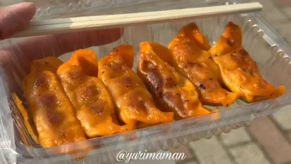 FM愛媛のキッチンカーで販売されたオレンジ色の「オーレ生餃子」。愛媛県産豚と麦味噌を使ったピリ辛餃子