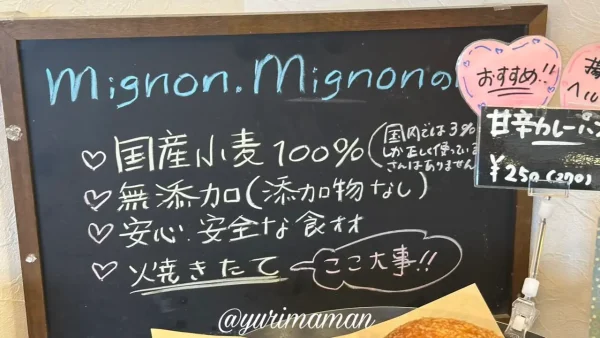 ミニョンミニョンの店内に掲示された素材へのこだわりボード（国産小麦100％・無添加・焼きたて）