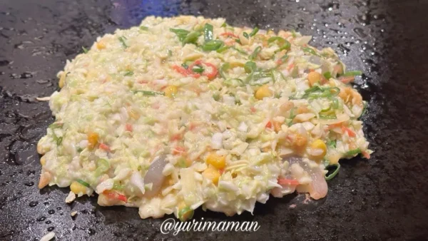 道とん堀新居浜店で、お好み焼きを鉄板で焼き始めたところ。具材がたっぷり入った生地の様子。