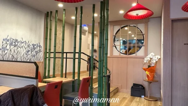 茶寮 伊藤園 松山市駅前店の店内。竹の装飾と赤い椅子が並ぶ和モダン空間