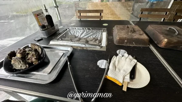 牡蠣奉行のBBQテーブルに並ぶトング、軍手、紙皿などのセット