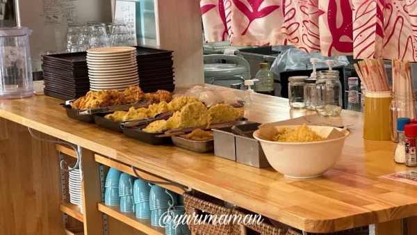 ハワイアンな雰囲気の店内に天ぷらが並ぶカウンター