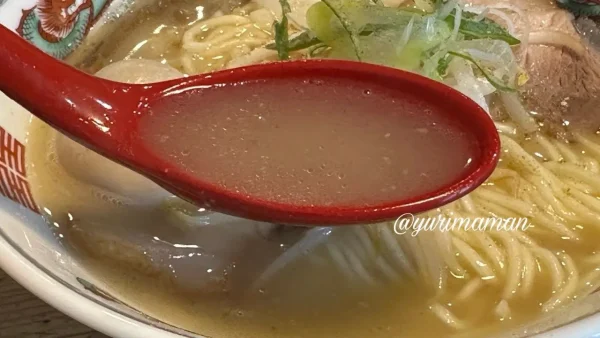 サムライノネイロのとんにぼラーメンの豚骨×煮干しスープをレンゲですくった写真 - ゆりママんブログ サムライノネイロのとんにぼラーメンの豚骨×煮干しスープをレンゲですくった写真