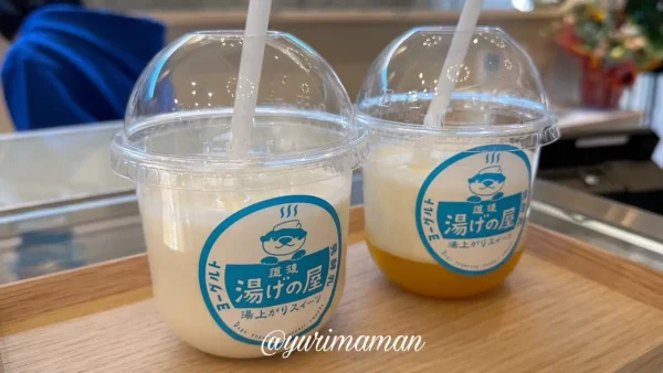 湯げの屋の飲むヨーグルトと、みかんジュレ入りクラフトヨーグルトのテイクアウトカップ。ゆげちゃんのロゴ入り。