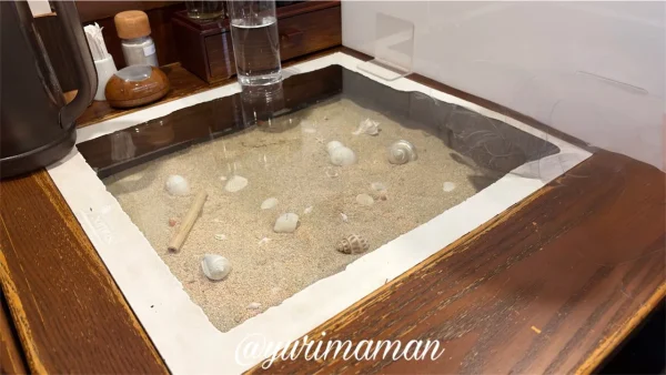 旧ハルピン店舗から移設された砂入りガラスカウンター席