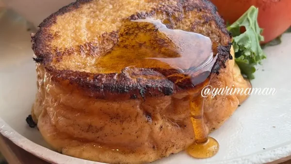フレンチトーストにメープルシロップをかける様子