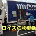 Blue Royce Chocolate Shop mobile truck with striped awning and an OPEN sign outside a crosswalk area.