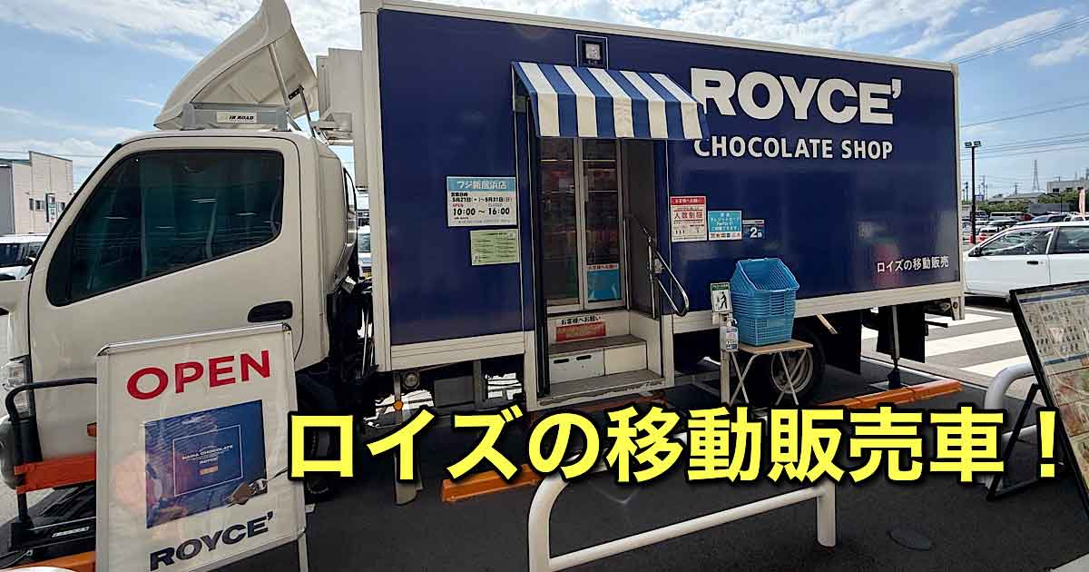 Blue Royce Chocolate Shop mobile truck with striped awning and an OPEN sign outside a crosswalk area.