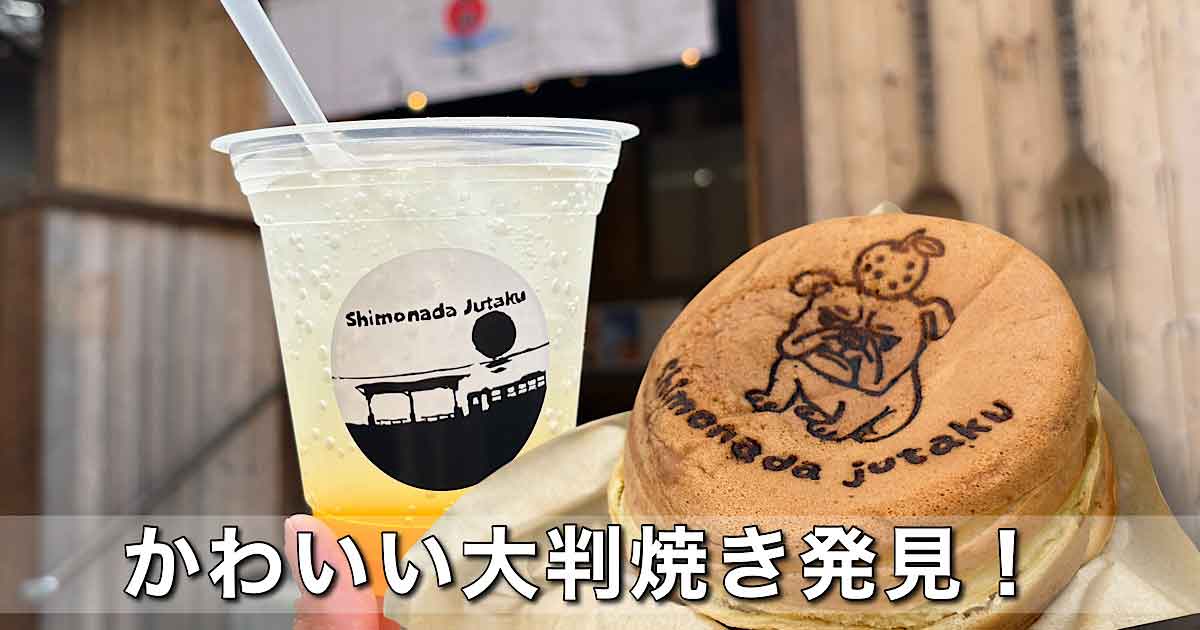 Plastic cup with straw and pale yellow beverage next to a round dorayaki pancake with a printed cartoon image on a wooden counter