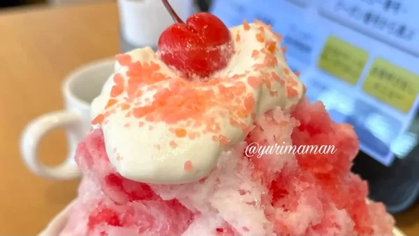 ガストのミニサイズいちごかき氷にパチパチキャンディをかけた様子
