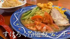 Blue plate of cold ramen with cucumber, tomato, egg strips, sliced pork, and sesame sauce; bottom caption reads すけろく冷麺夏ランチ.