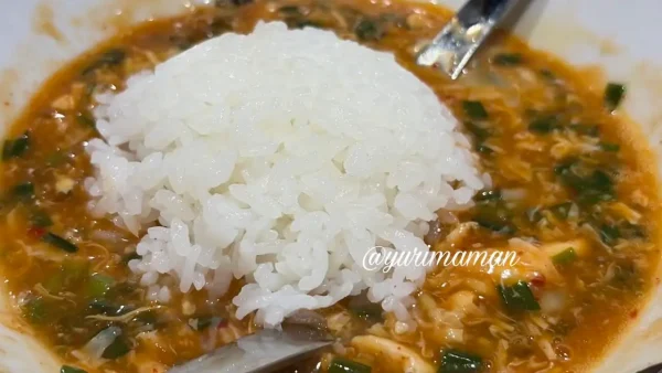 ジャン麺の残ったスープにご飯を入れている様子