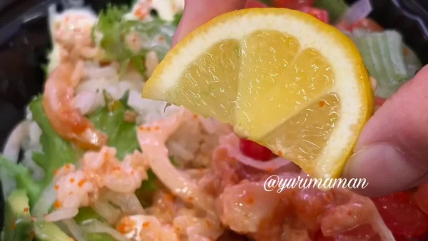 スシローのポキ丼にレモンを搾る様子