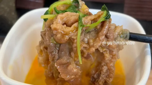 吉野家の牛すき鍋膳の牛肉を生卵につけて実食